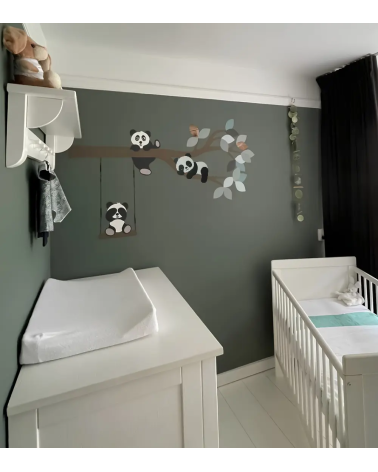 Behangsticker met pandabeertjes op een tak in een donker groene babykamer.