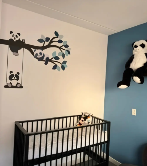 Panda muurdecoratie in een blauwe jongenskamer van een tak met pandabeertjes.