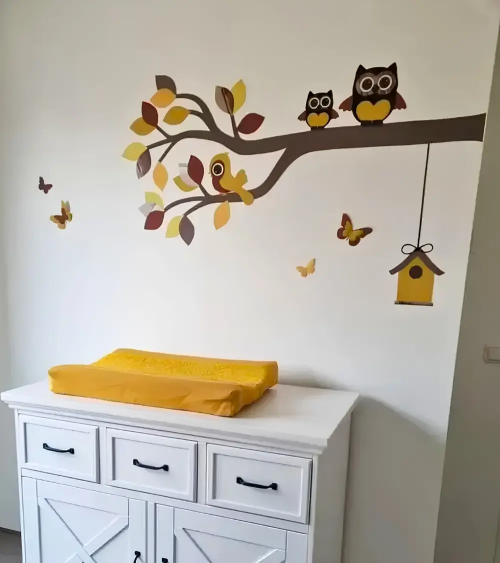 Behangsticker babykamer sierlijke uilentak okergeel en roestbruin.