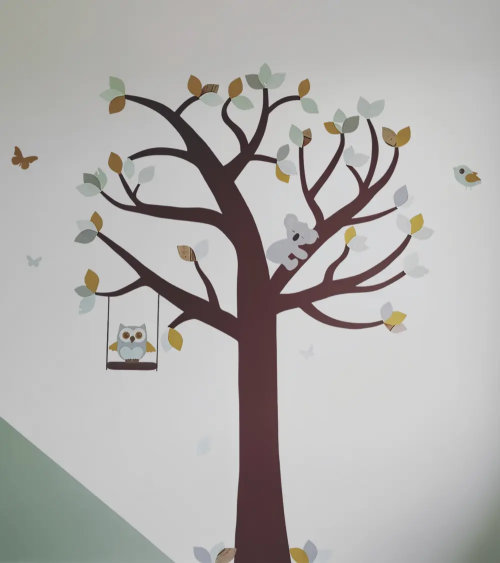 Behang muurdecoratie babykamer grote boom met dieren in mintgroen en okergeel.