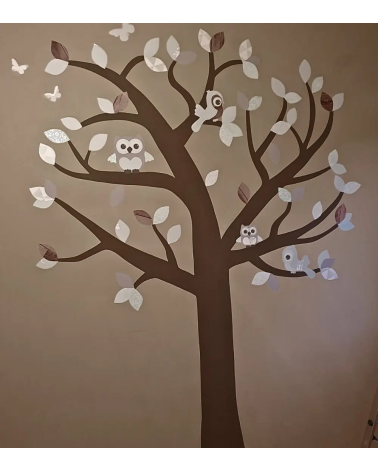Neutrale boom muurdecoratie kinderkamer met mintgroene bladeren op een bruine muur.