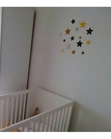 Set sterren behangstickers babykamer okergeel boven ledikantje.