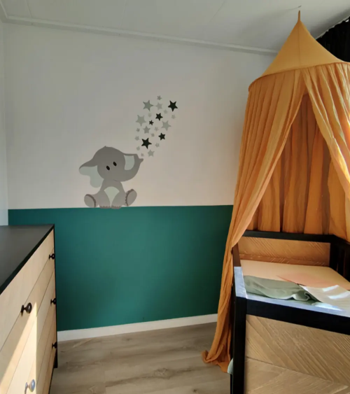 Donkergroen en okergele babykamer met olifant behangsticker met set sterren.