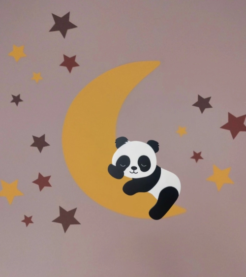 Behangsticker slapende pandabeer op een okergele maan met terracotta sterren op een oudroze muur.
