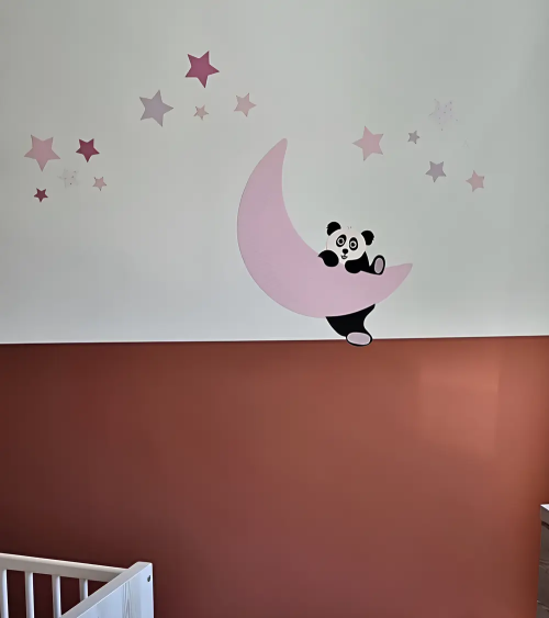 Behangsticker van een roze maan met sterren en een pandabeertje dat op de maan klimt.
