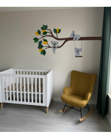 Behangsticker tak met koalaberen in donkergroen en oker in een beige jongensbabykamer.