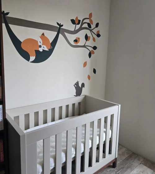 Behangsticker babykamer van een tak met een slapend vosje in hangmat donkergroen, oranje