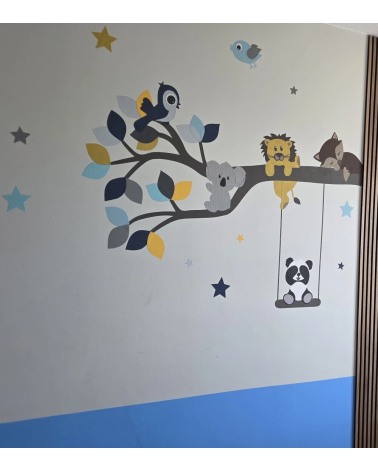 Een behangsticker van een blauwe en okergele tak met lieve diertjes, zoals een leeuwtje, vosje, panda, koala en vogels.