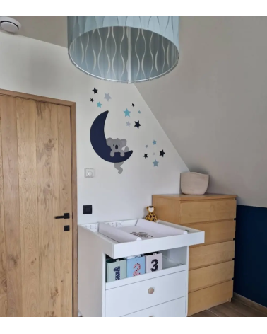 Jongenskamer behangsticker van een klimmende koala op een donkerblauwe maan met sterren.