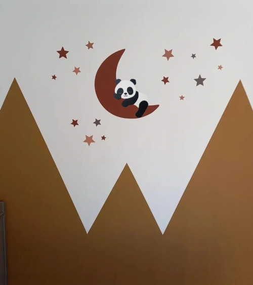 Slapende pandabeer op de maan roest op een gouden muur in de babykamer.