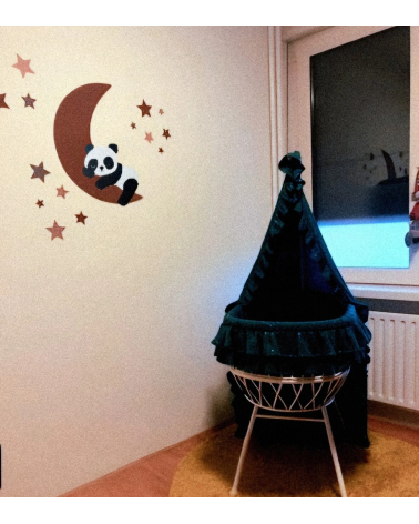 Slapende pandabeer op de maan roest boven het wiegje in de babykamer.
