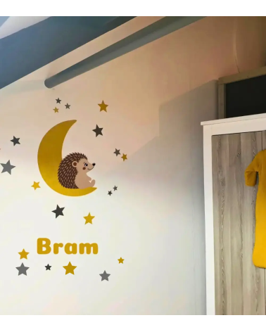 Okergele maan behangsticker voor de kinderkamer met naamletters, een egeltje en sterren.