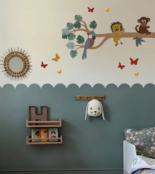 Donkergroene jungle tak muurdecoratie in een donkergroene kinderkamer.