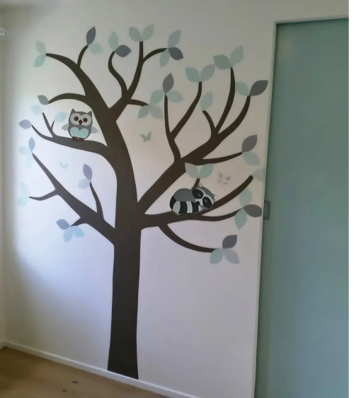 Mintgroene behangboom met bosdieren in een mintgroene kinderkamer.