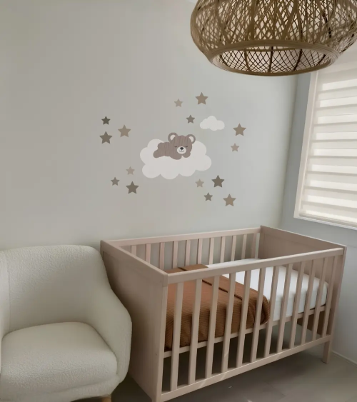 Behangsticker teddybeer op wolk in een beige babykamer met extra sterren.