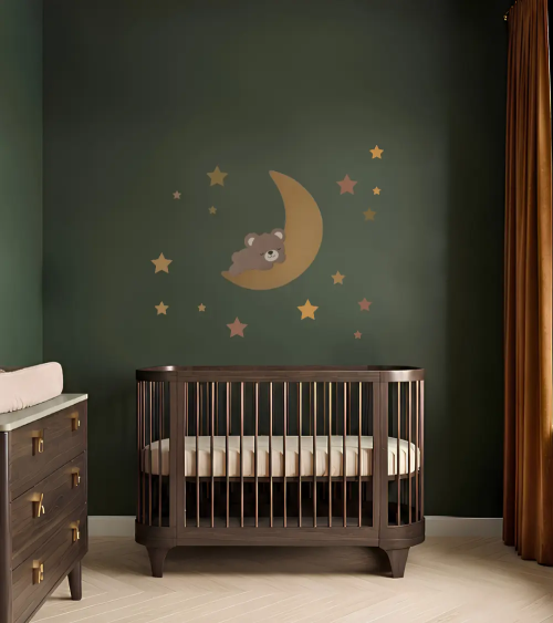 Muurdecoratie van vliesbehang van een gouden maan met een slapende teddybeer in een donkergroene kinderkamer.
