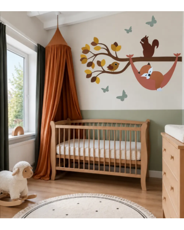 Een okergele bosdieren tak met een slapend vosje in een hangmat in een saliegroen en terracotta babykamer