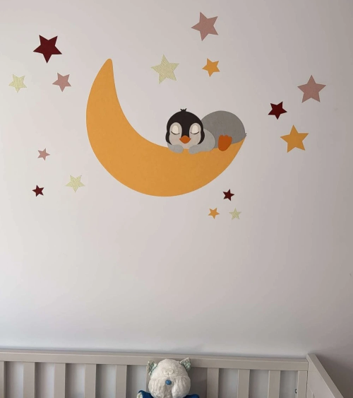 Muursticker van behang met een pinguin op de maan in oker, roest, roze en groen.