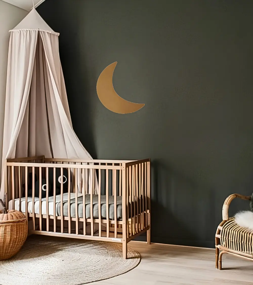 Gouden maan muurdecoratie van vliesbehang in donkergroene babykamer.