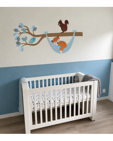 Bosdieren tak muurdecoratie met een slapend vosje in een hangmat in een lichtblauwe jongens babykamer.